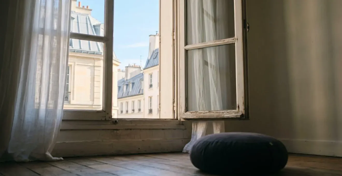 Vue minimaliste d'une fenêtre parisienne avec fragment de ciel entre deux immeubles